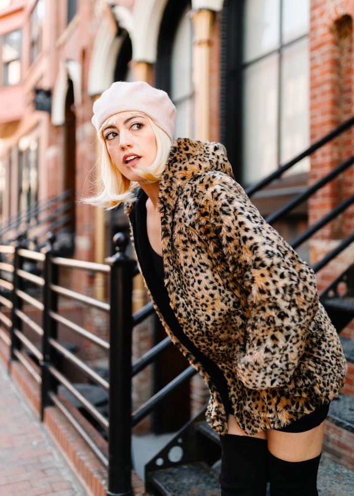 Fashionable woman in leopard print coat posing outdoors in Des Moines, Iowa, showing urban chic style.