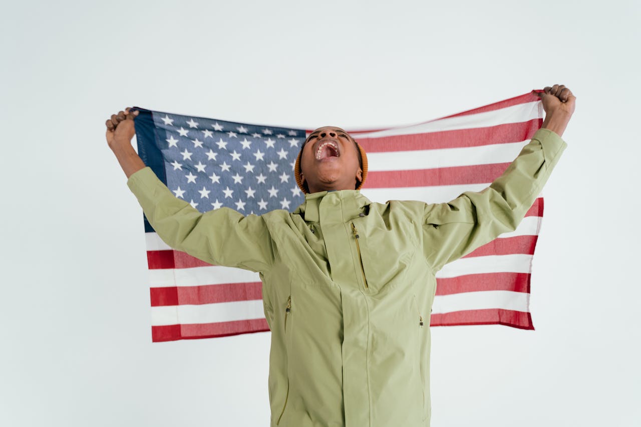 Person joyfully holds an American flag, symbolizing patriotism and freedom.