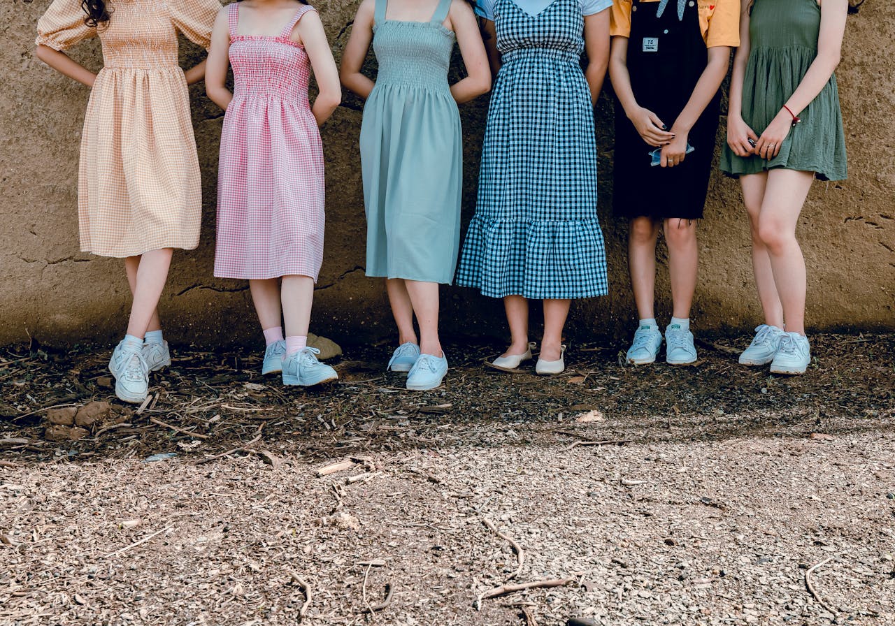 Group of women in vibrant dresses standing outdoors, showcasing summer fashion style.